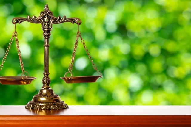 緑背景の法律を象徴する天秤イラスト