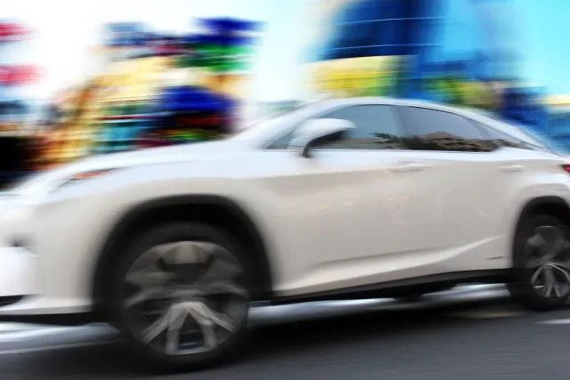高速走行でぼやけた白いスポーツカー、モーションブラー効果