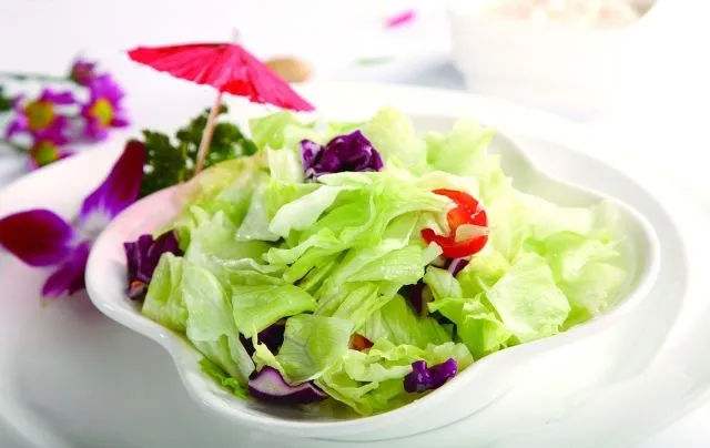 生の野菜が盛られた白い皿。体を冷やす可能性がある生野菜のイメージ