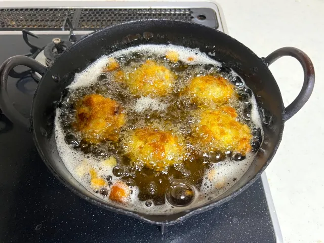 鍋の中で油が沸騰し、揚げ物をしている様子