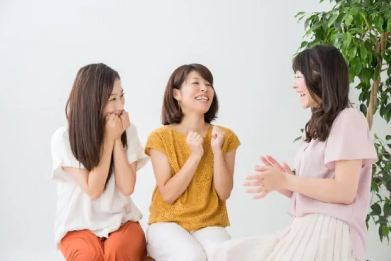 3人の女性が座って笑いながら話し合う様子