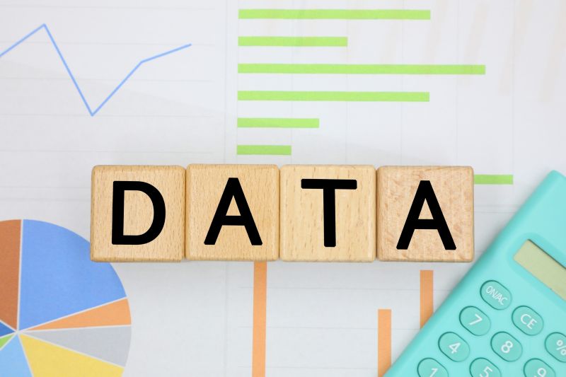 円グラフ・棒グラフ・折れ線グラフとDATAの木製ブロックが並ぶデータ分析のイメージ画像