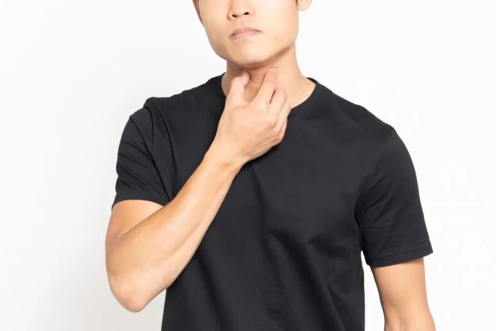 風邪後に声が出ない男性が喉を押さえている様子