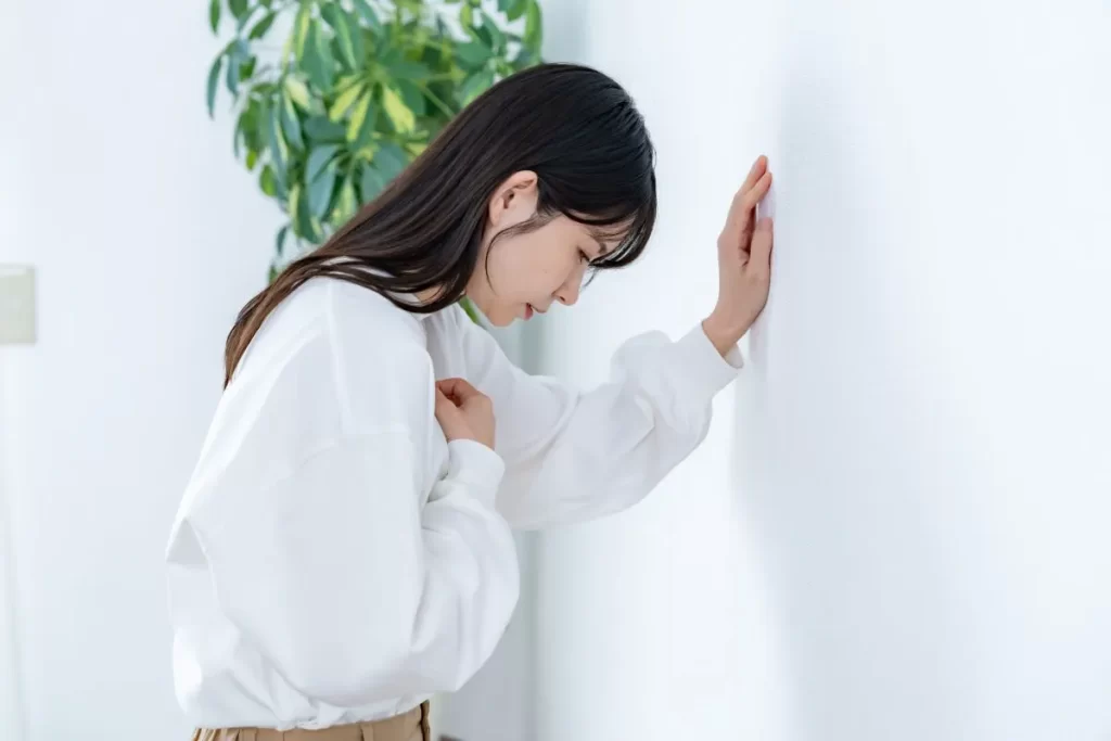 呼吸困難と強い倦怠感により胸を押さえる女性のイメージ